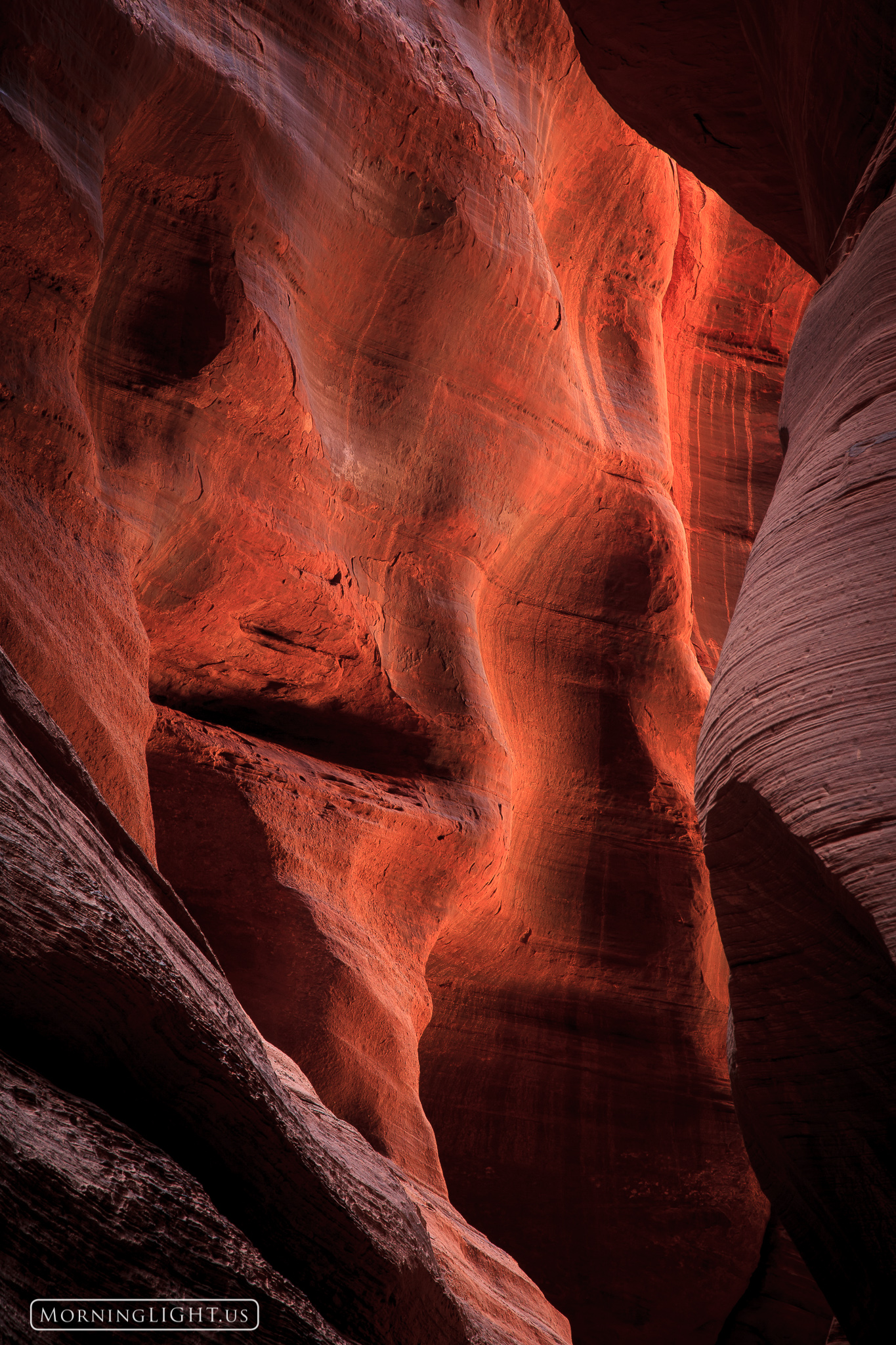 A distant wall in Bukskin Gulch glows with reflected light revealing unusual textures.