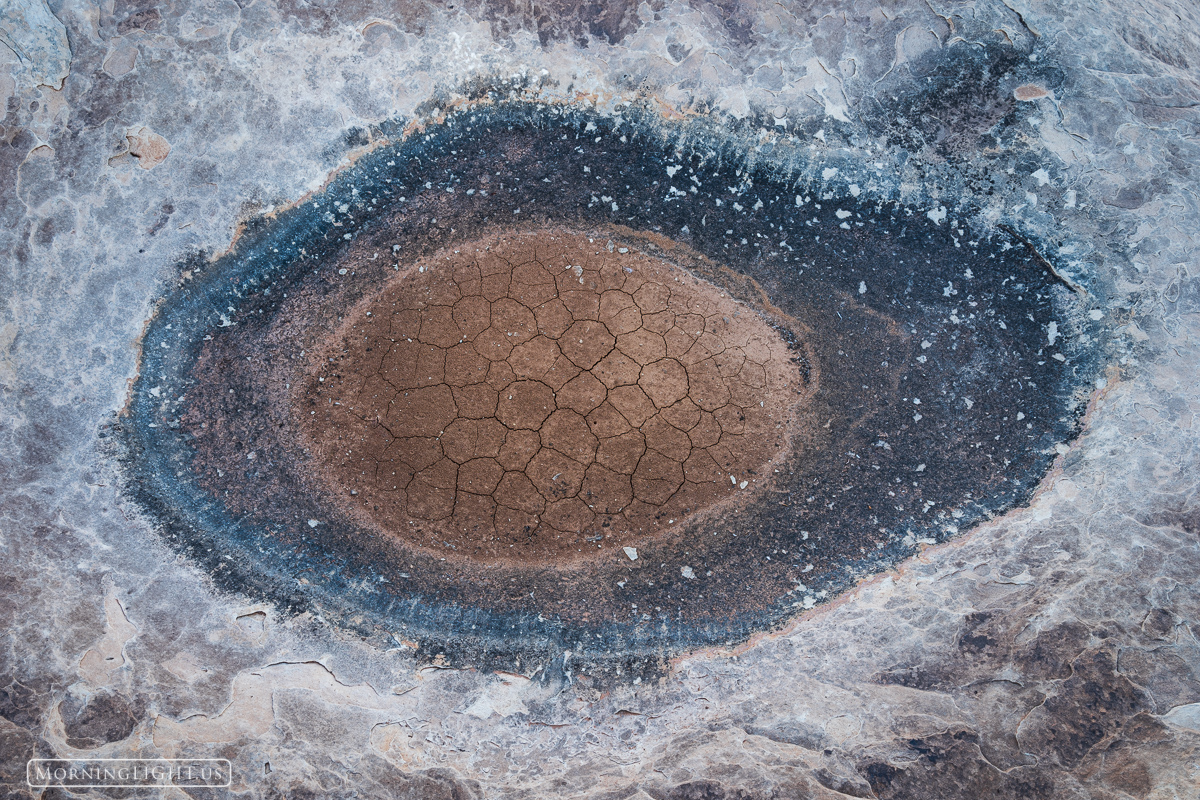 A shallow depression in the slickrock in a remote area of southern Utah collects water which then evaporates. Through this process...