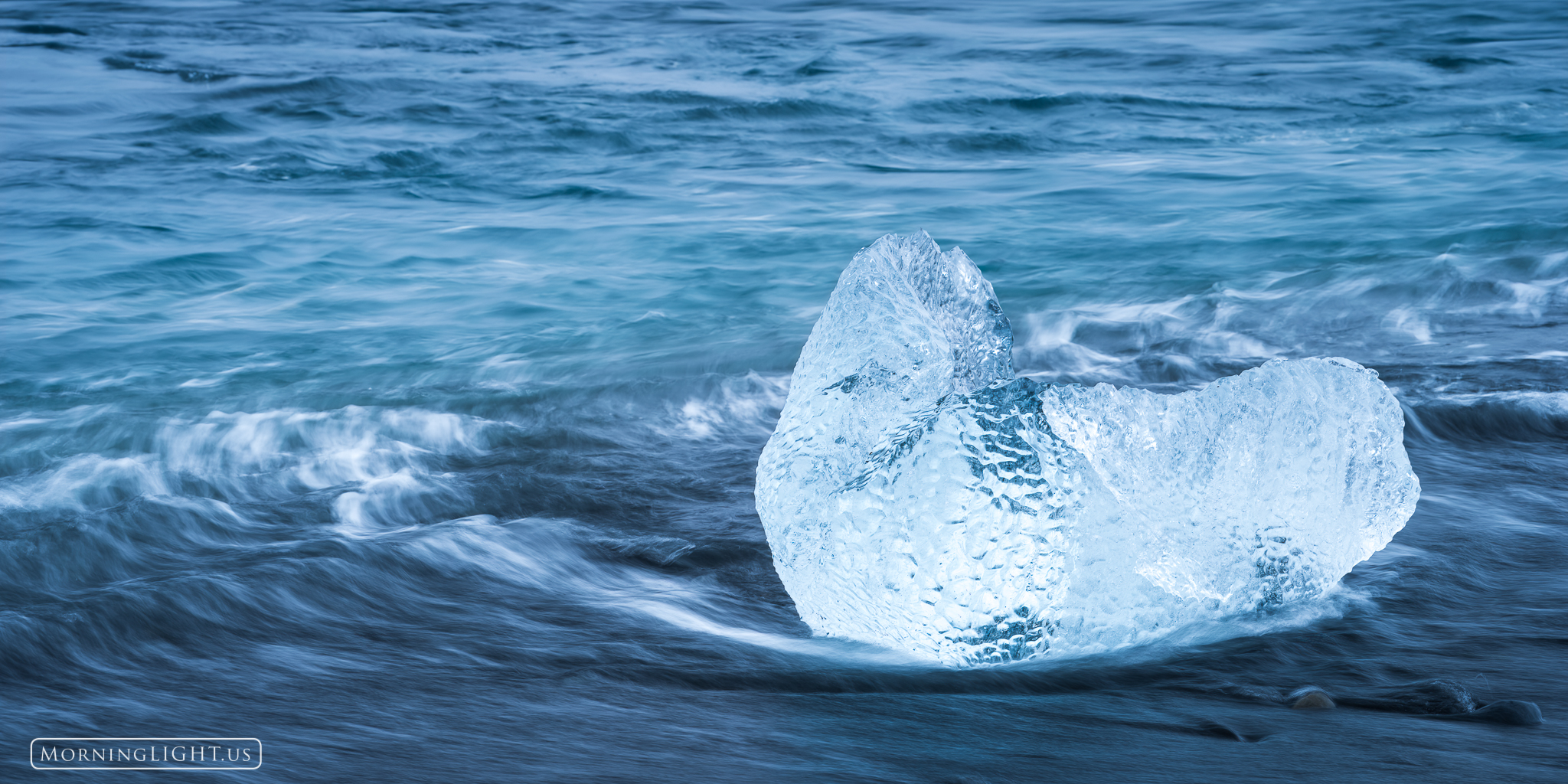 As an iceberg broke free of the glacier, it eventually found its way to the open ocean. There, the warmer water and crashing...