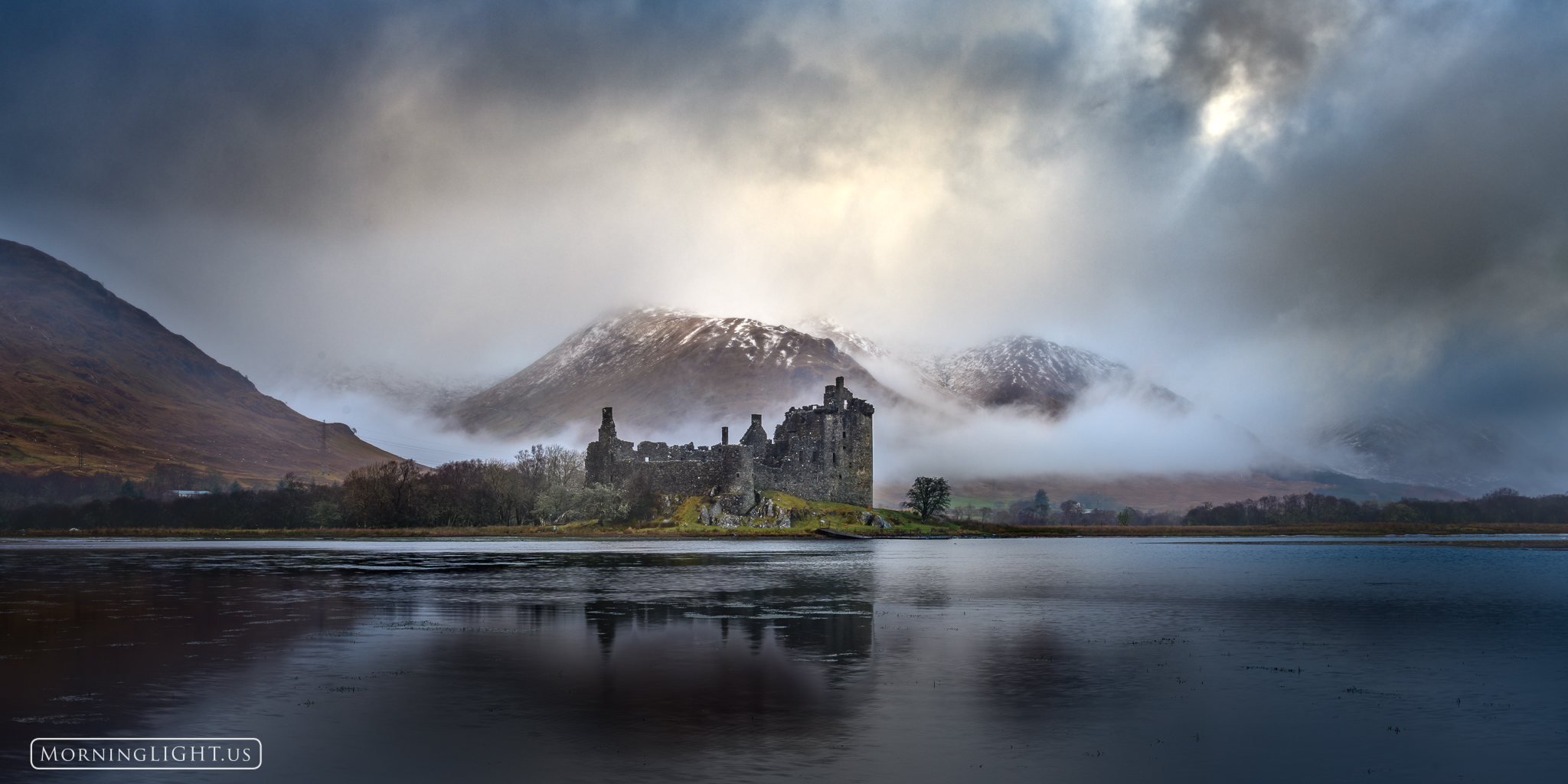 Kilchurn Castle in the Highlands of Scotland appears calm despite the surrounding storm.