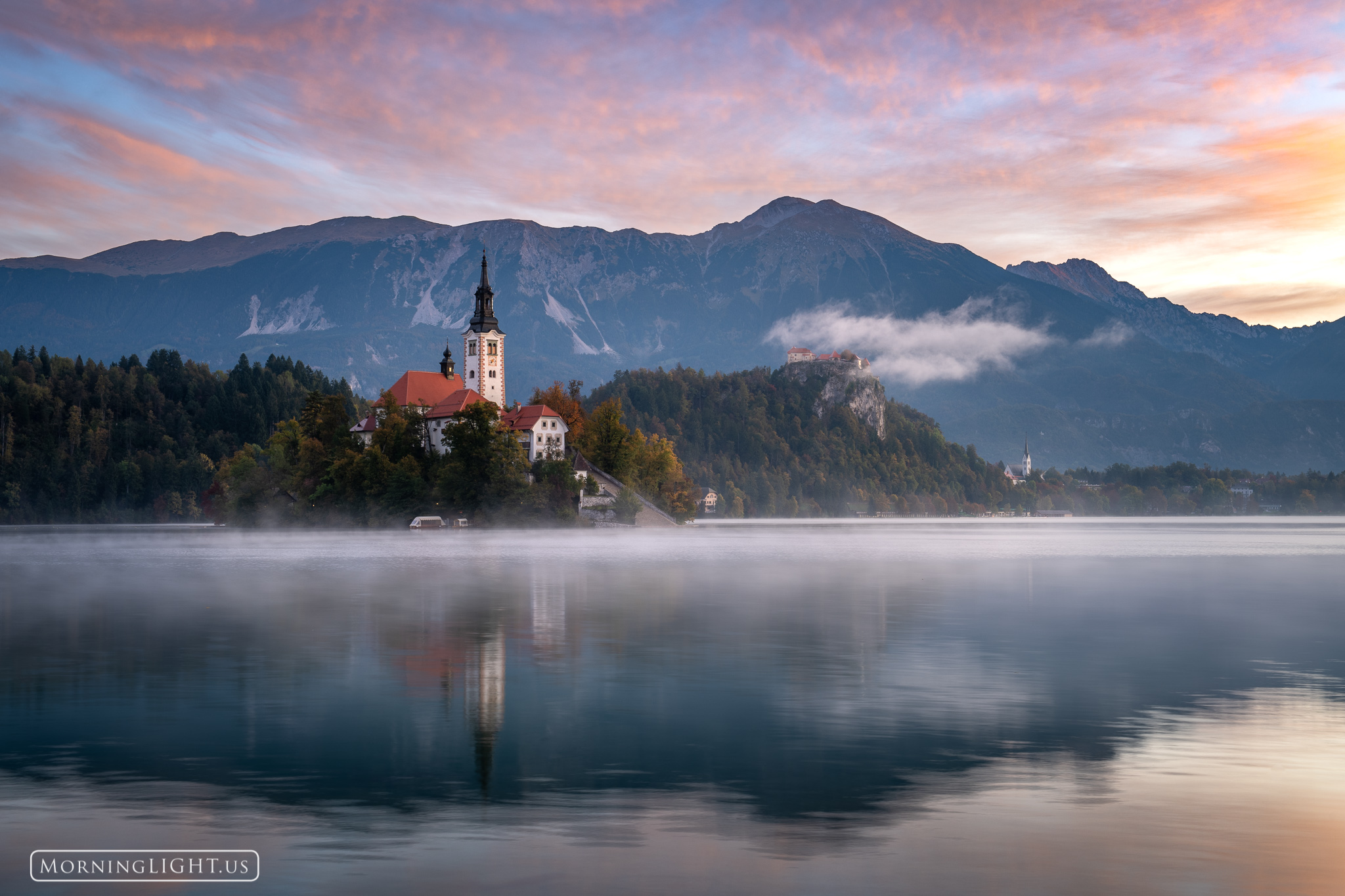 Fog floats over Lake Bled and above the fairyland castle perched high above the lake on this glorious October morning.