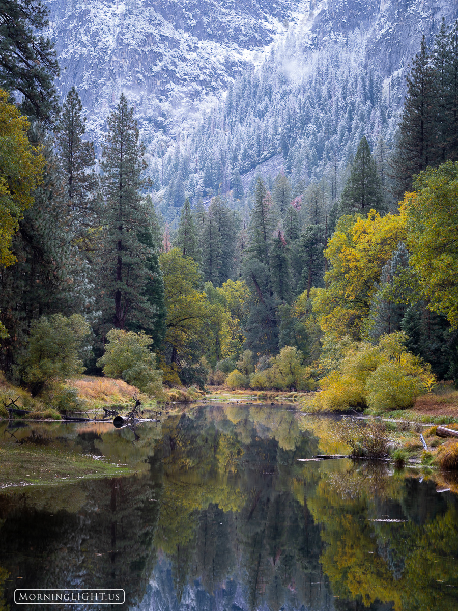 The first snow of the year coats the high country of Yosemite National Park. Meanwhile the Merced River gently flows on, as if...